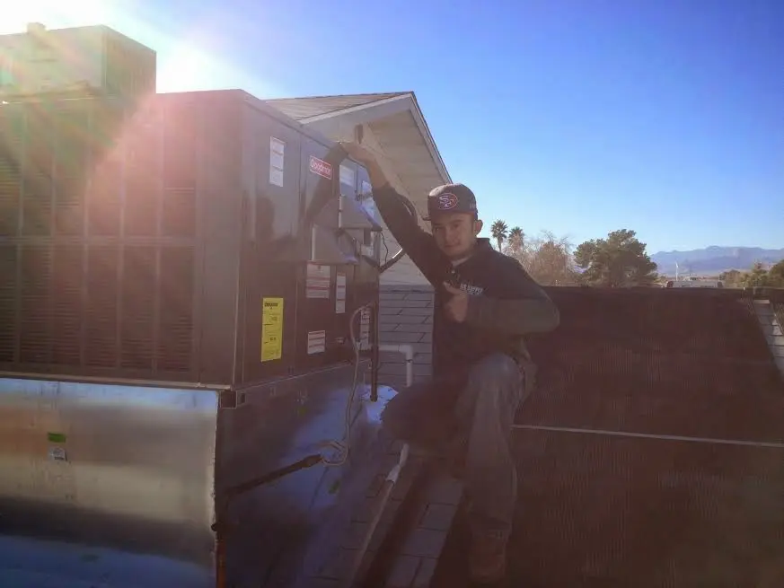 HVAC technician performing Boiler Repair on a rooftop unit in Lacy-Lakeview